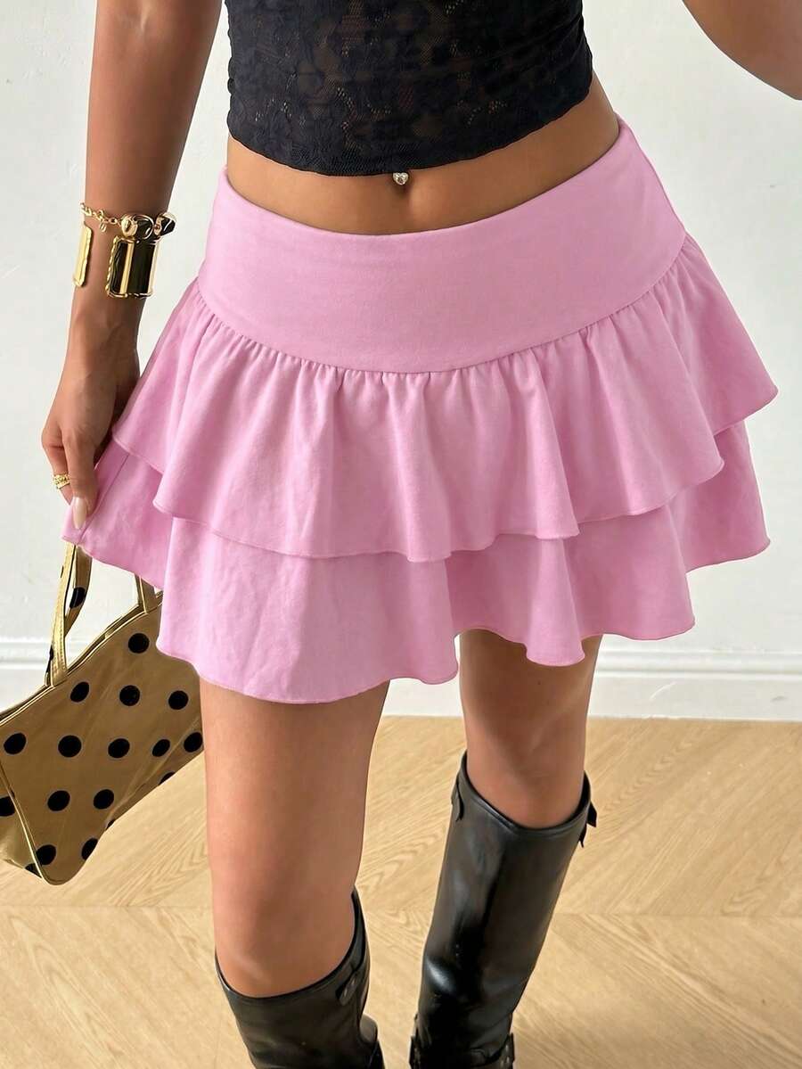 Black low waist knit mini skirt featuring a tiered ruffle hem and skinny high stretch fit.