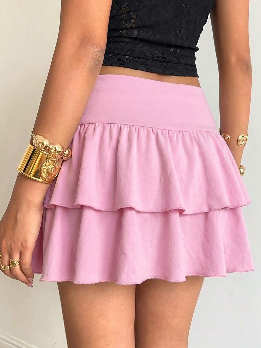 Black low waist knit mini skirt featuring a tiered ruffle hem and skinny high stretch fit.
