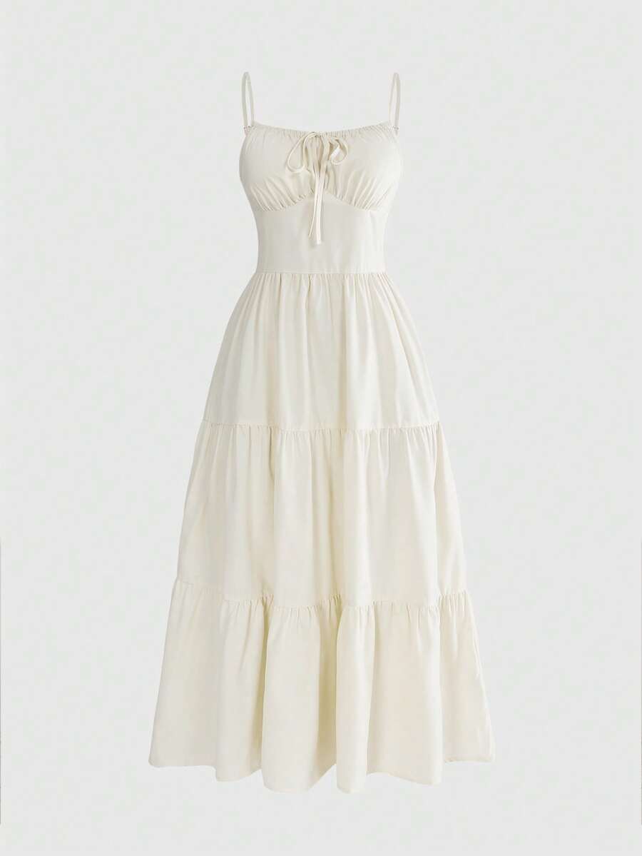 Women wearing a solid color boho spaghetti strap long dress with a ruched bust, high waist, and tiered ruffle hem.