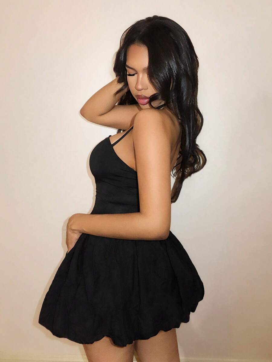 BamGlam women's black mini cami dress featuring a deep V-neckline with hollowed-out crisscross straps, spaghetti straps, and a flared hem.