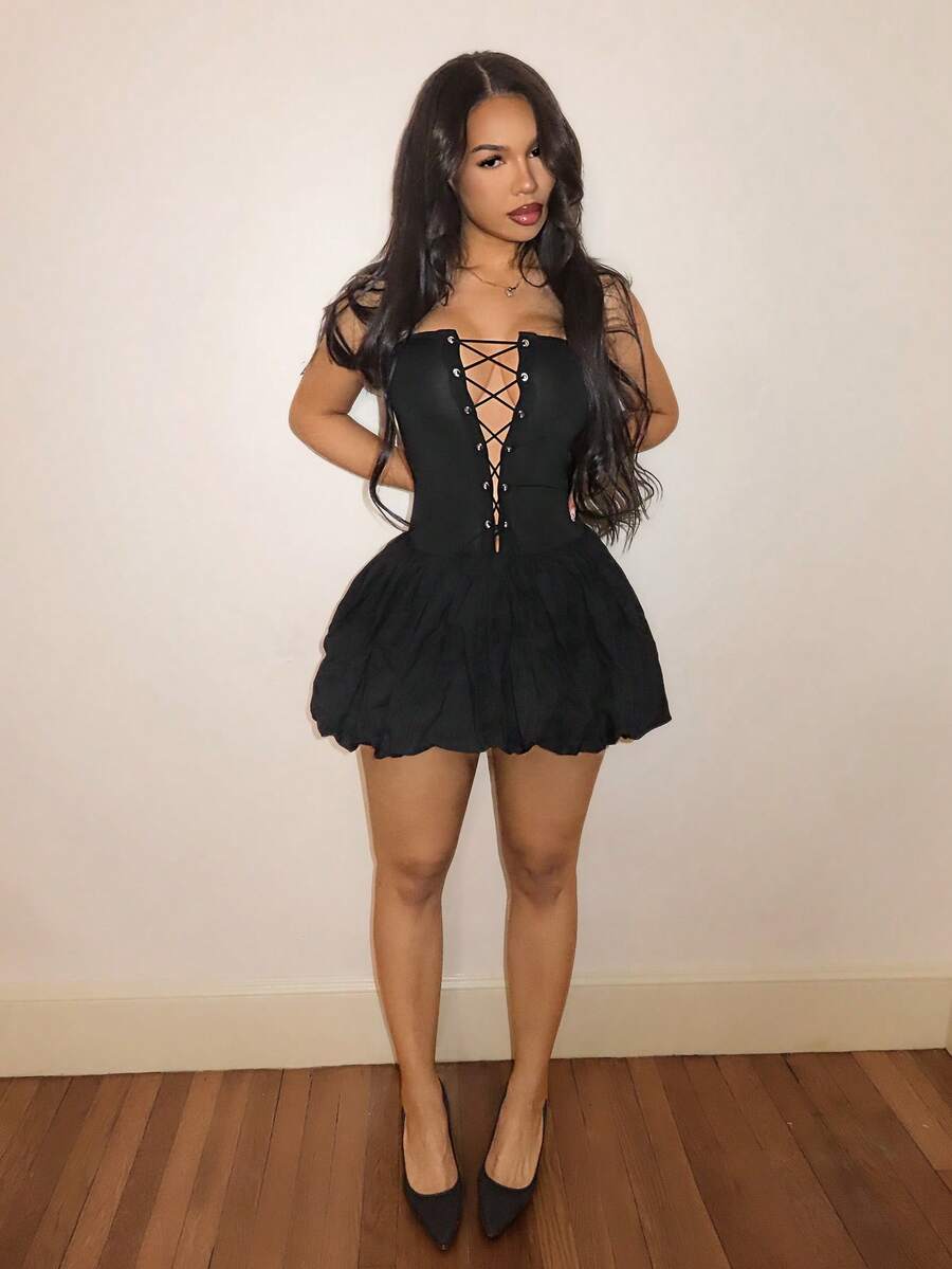 BamGlam women's black mini cami dress featuring a deep V-neckline with hollowed-out crisscross straps, spaghetti straps, and a flared hem.
