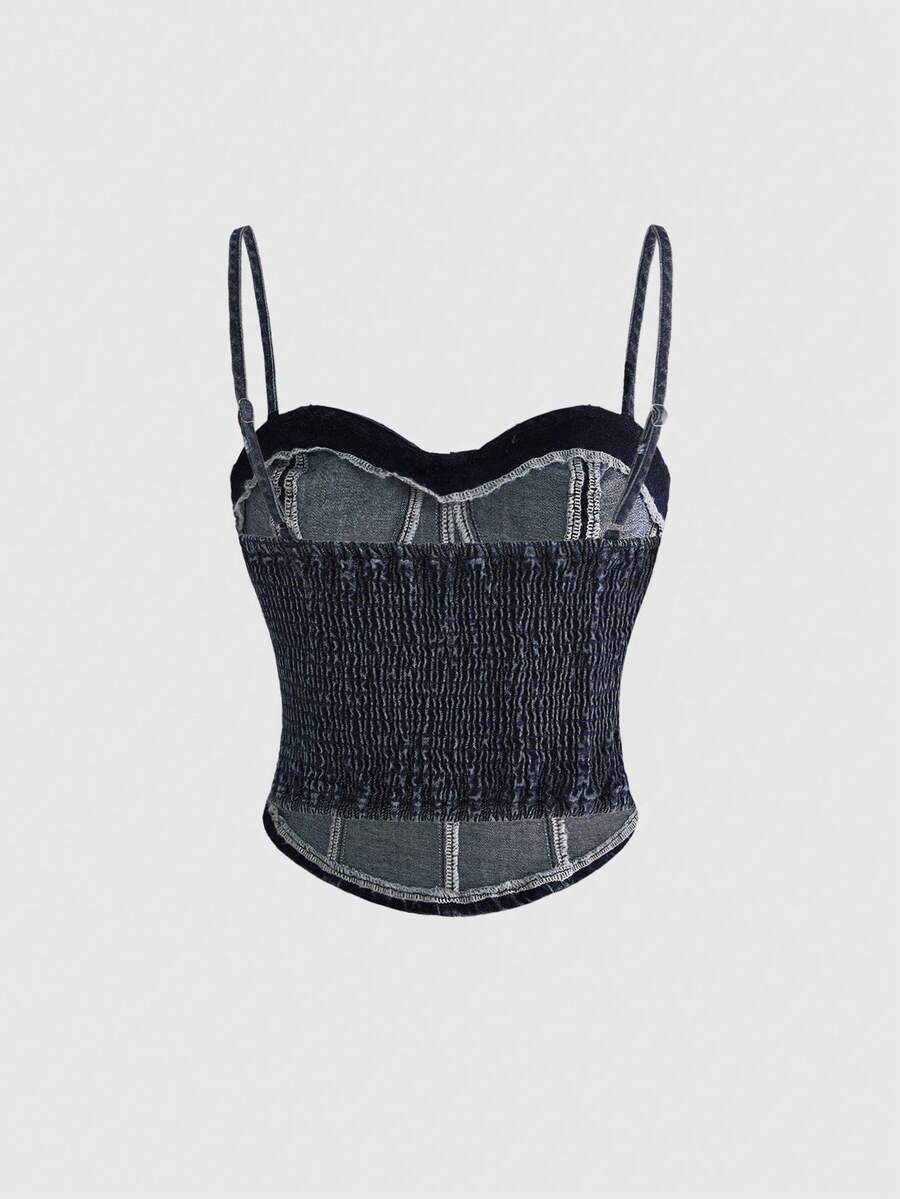 Dark wash denim camisole top for women with rhinestone embellishments, spaghetti straps, front zipper closure, and an asymmetrical micro crop hem.
