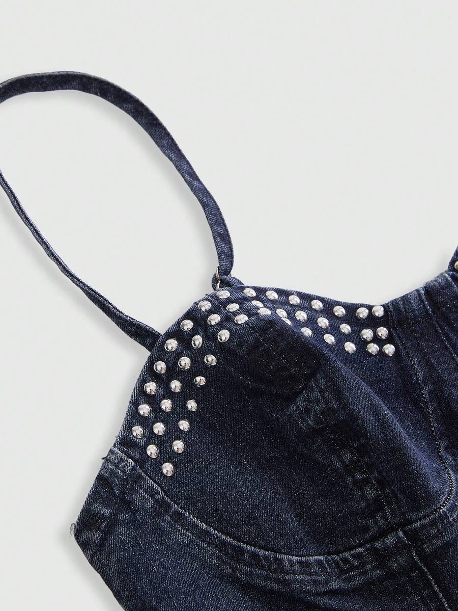 Dark wash denim camisole top for women with rhinestone embellishments, spaghetti straps, front zipper closure, and an asymmetrical micro crop hem.