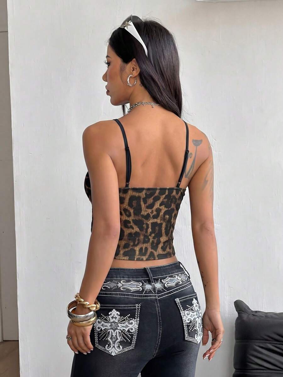 Women's black lace cami crop top featuring spaghetti straps, semi-sheer plant pattern fabric, and a backless design.