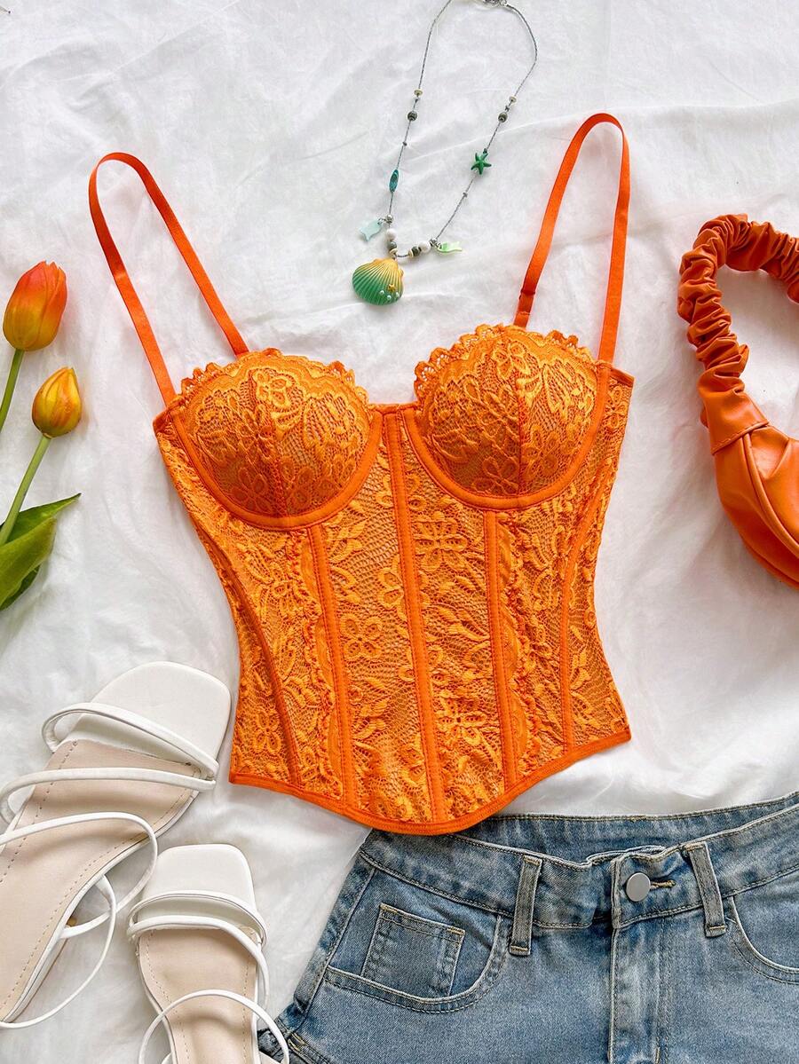 Women's lace bustier camisole top with spaghetti straps, contrast lace, lace-up detail, and an asymmetrical hem in a slim fit design.