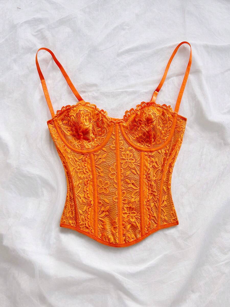 Women's lace bustier camisole top with spaghetti straps, contrast lace, lace-up detail, and an asymmetrical hem in a slim fit design.