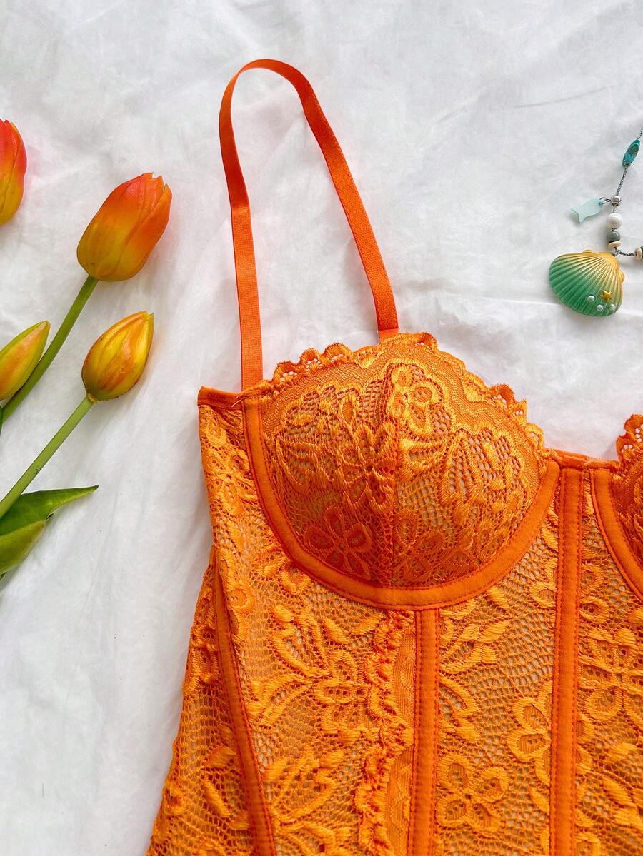Women's lace bustier camisole top with spaghetti straps, contrast lace, lace-up detail, and an asymmetrical hem in a slim fit design.