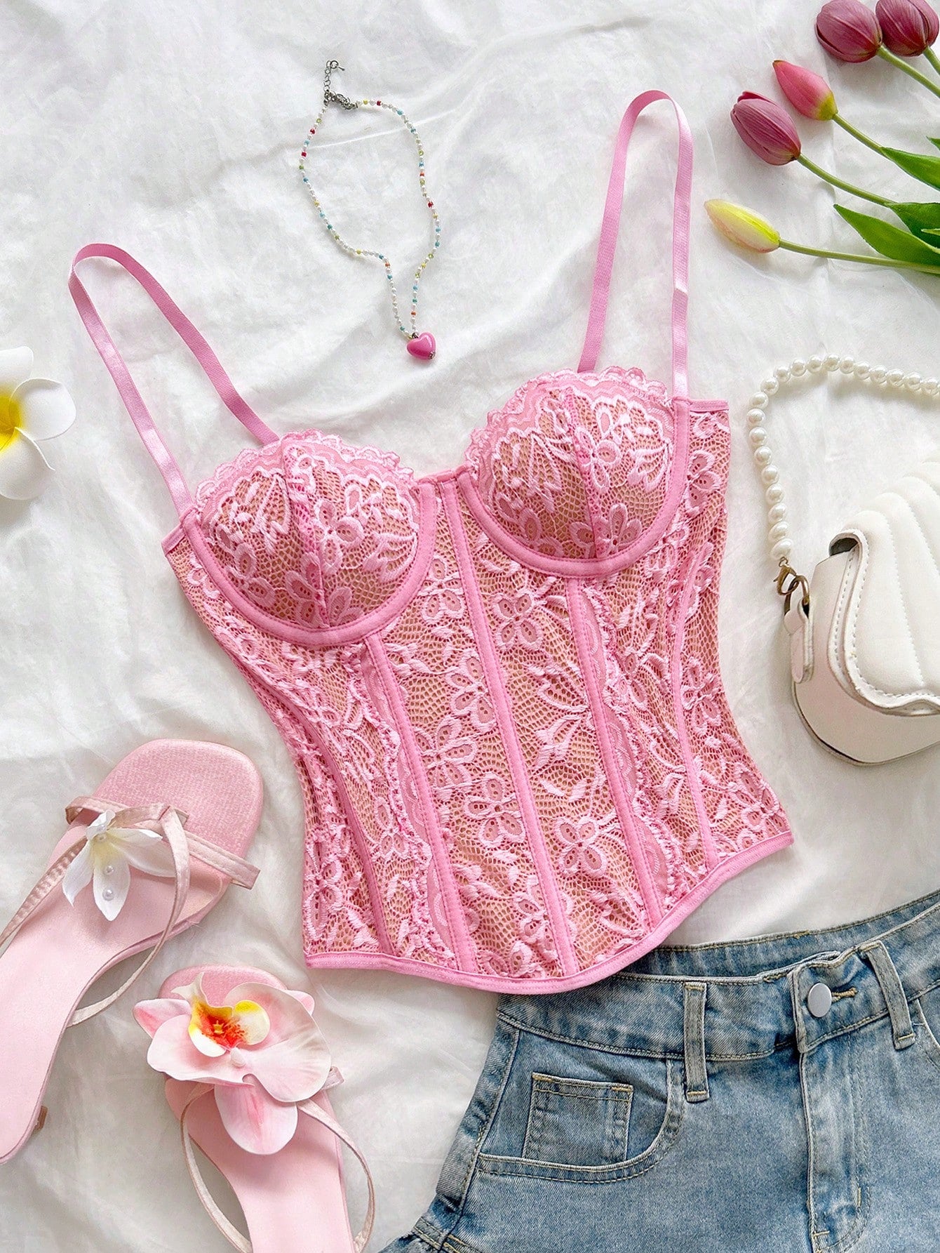 Women's lace bustier camisole top with spaghetti straps, contrast lace, lace-up detail, and an asymmetrical hem in a slim fit design.