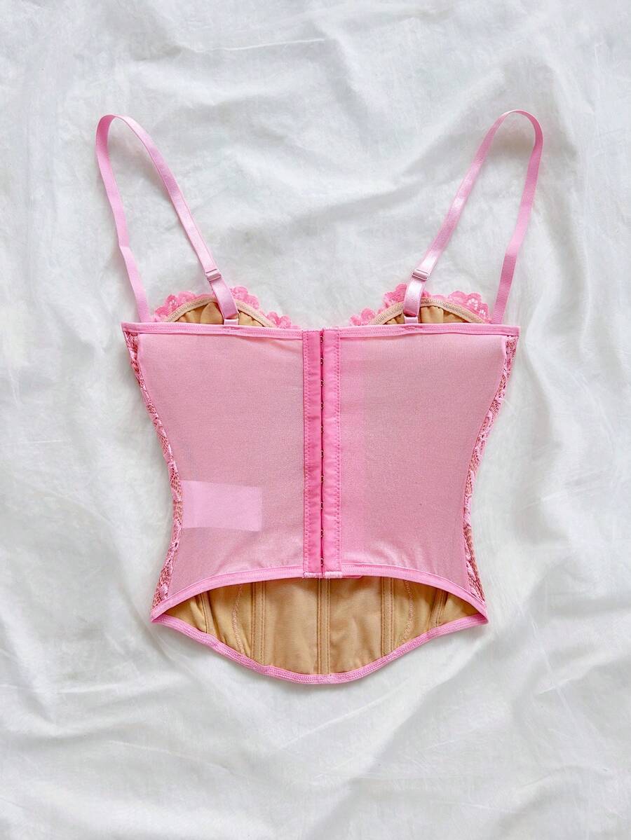 Women's lace bustier camisole top with spaghetti straps, contrast lace, lace-up detail, and an asymmetrical hem in a slim fit design.