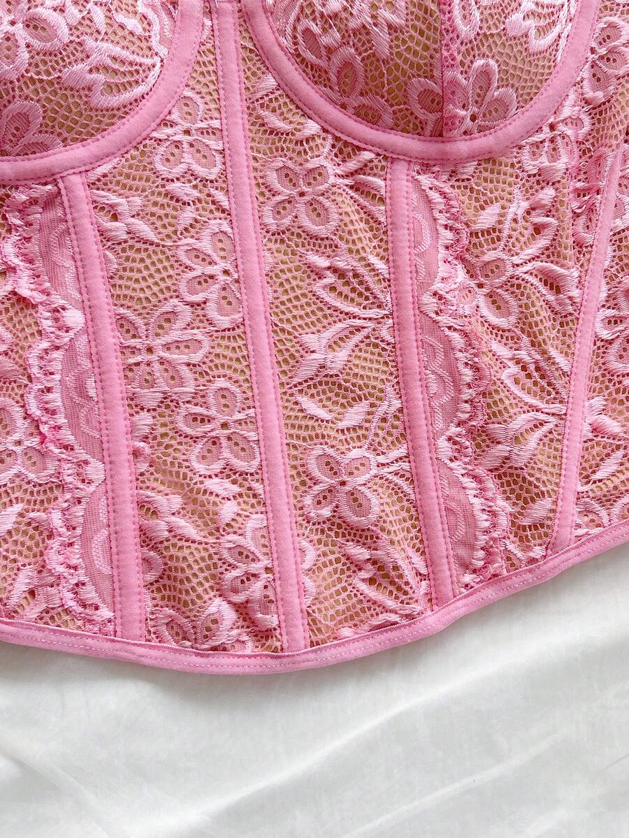 Women's lace bustier camisole top with spaghetti straps, contrast lace, lace-up detail, and an asymmetrical hem in a slim fit design.