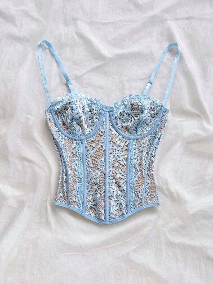 Women's lace bustier camisole top with spaghetti straps, contrast lace, lace-up detail, and an asymmetrical hem in a slim fit design.