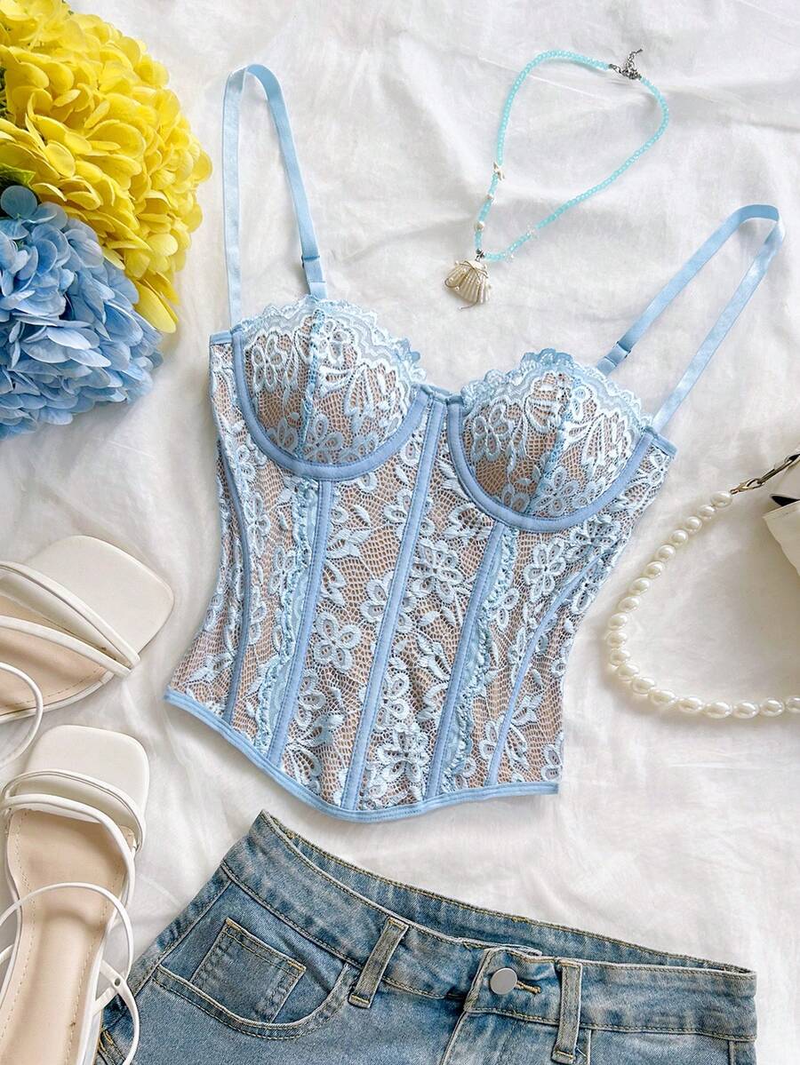 Women's lace bustier camisole top with spaghetti straps, contrast lace, lace-up detail, and an asymmetrical hem in a slim fit design.