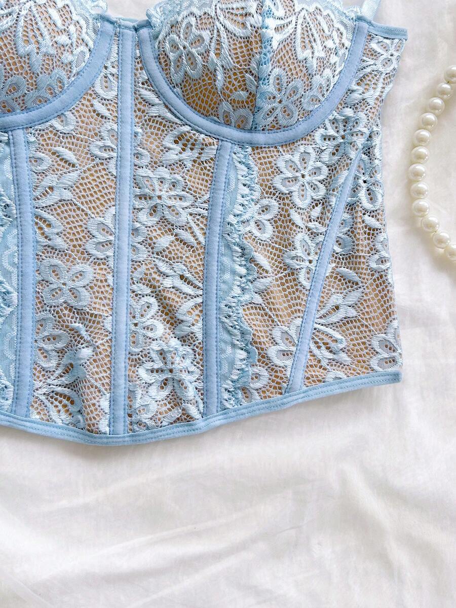 Women's lace bustier camisole top with spaghetti straps, contrast lace, lace-up detail, and an asymmetrical hem in a slim fit design.