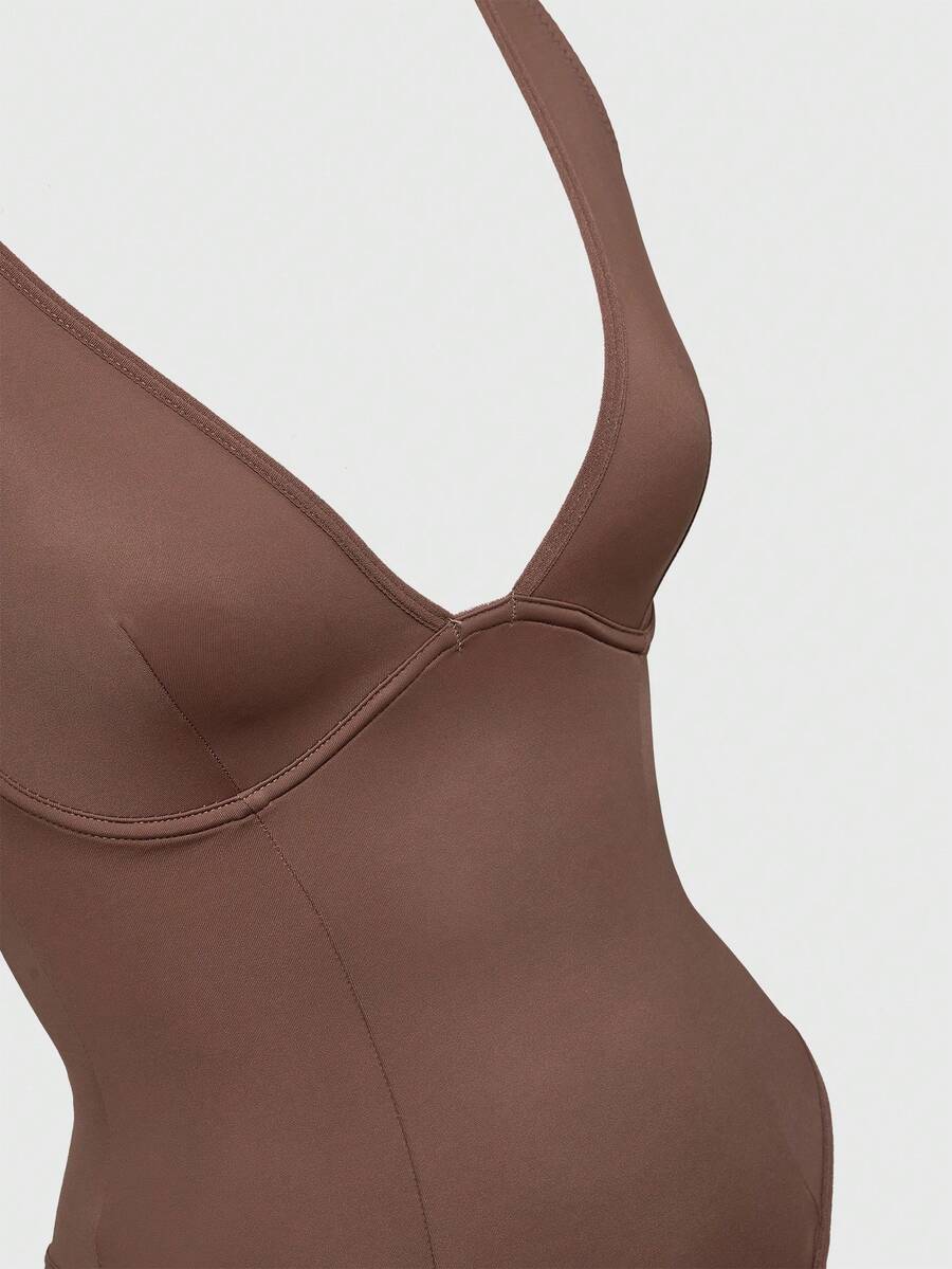 Apricot backless shapewear bodysuit with thong cut, cup details, and high-stretch fabric for light tummy support.
