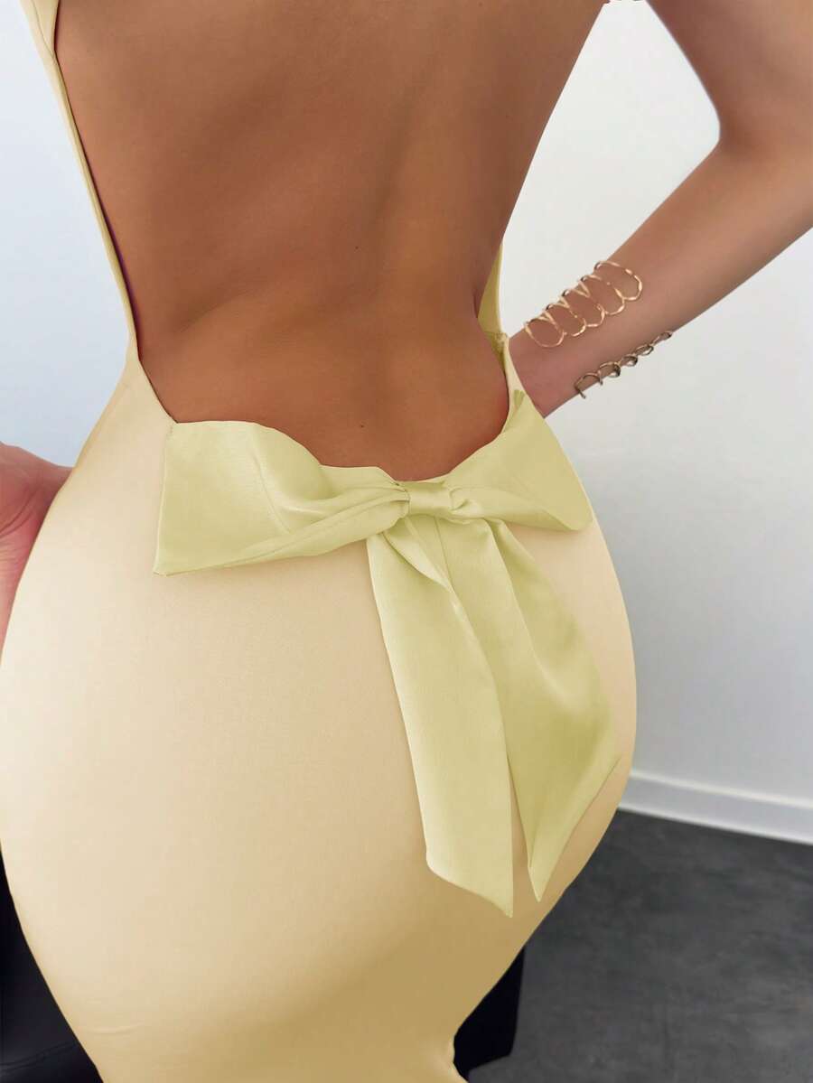 Beige sleeveless backless cami maxi dress for women featuring bow decor, split hem, and slim fit knitted fabric.