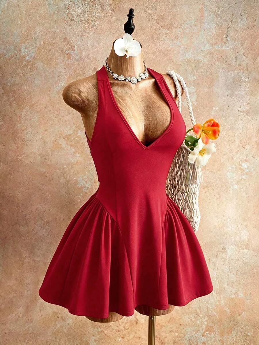 Sleeveless black halter mini dress for women featuring a high waist, A-line flared hem, and criss cross details.