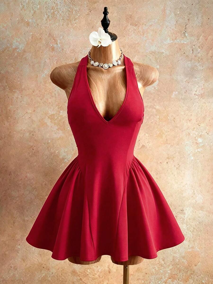 Sleeveless black halter mini dress for women featuring a high waist, A-line flared hem, and criss cross details.