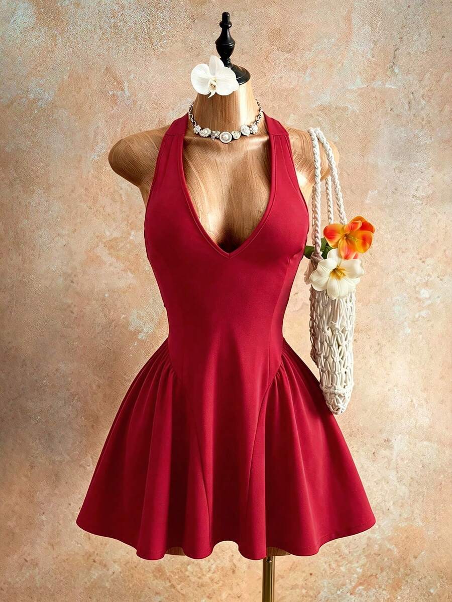 Sleeveless black halter mini dress for women featuring a high waist, A-line flared hem, and criss cross details.