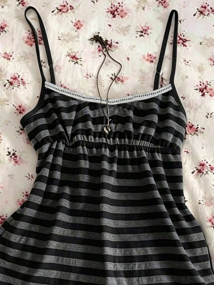 A women's black striped camisole top featuring spaghetti straps, a backless design with ring detail, and high-stretch knitted fabric.