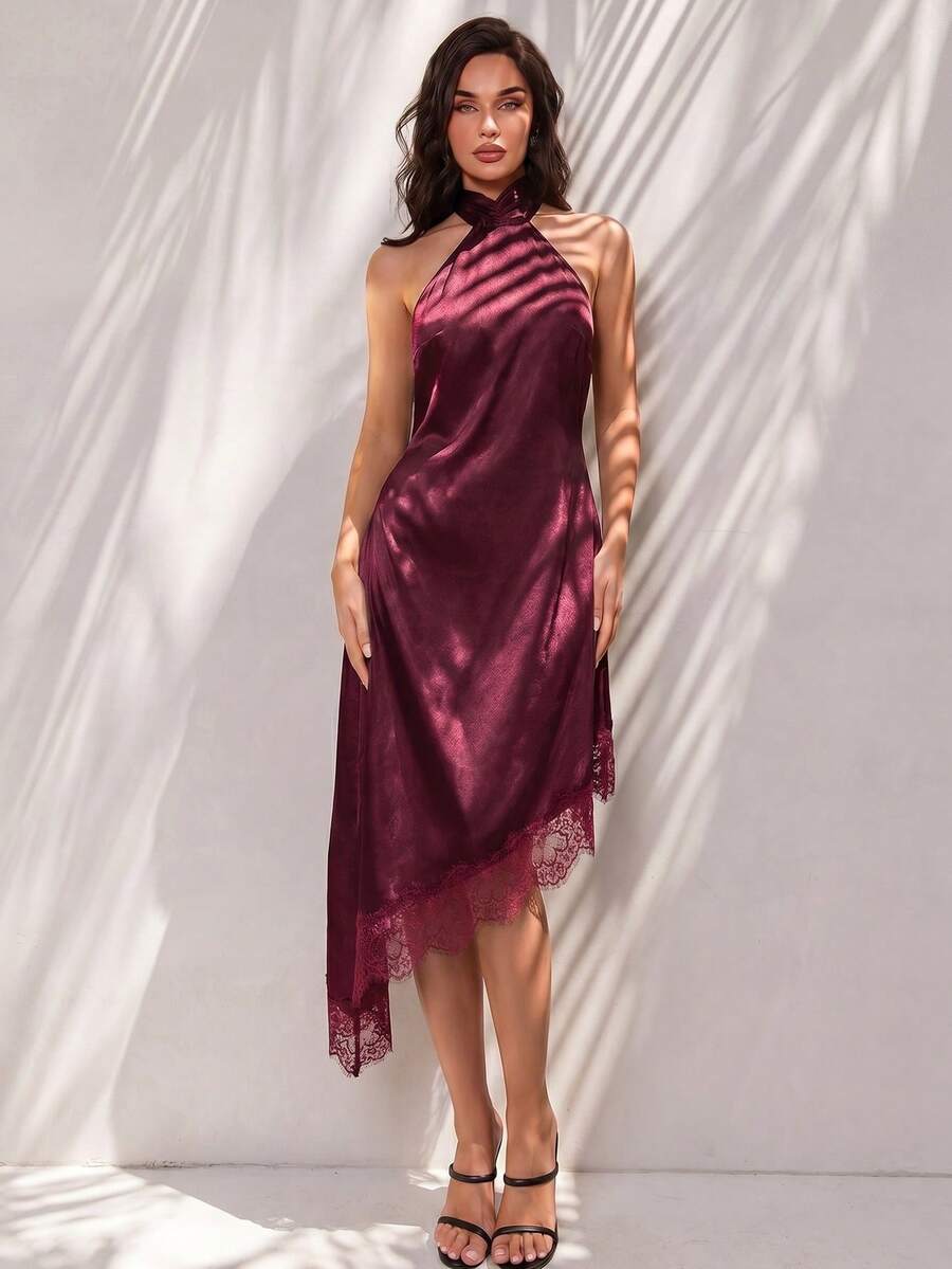 Black halter neck mini dress for women featuring a backless design with a large bow detail and an asymmetric contrast lace hem.