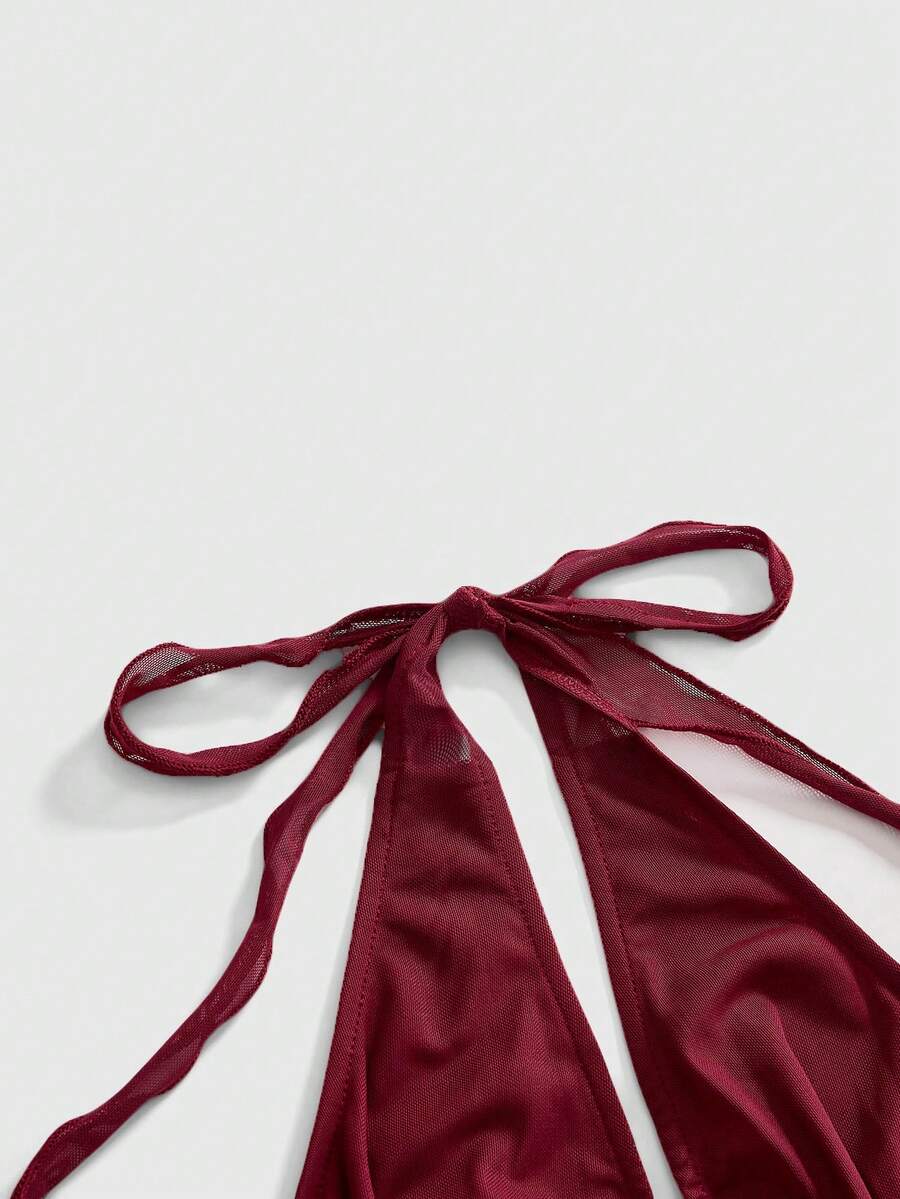 Women's pink backless halter top with rhinestone decor, knot detail, and asymmetrical hem.