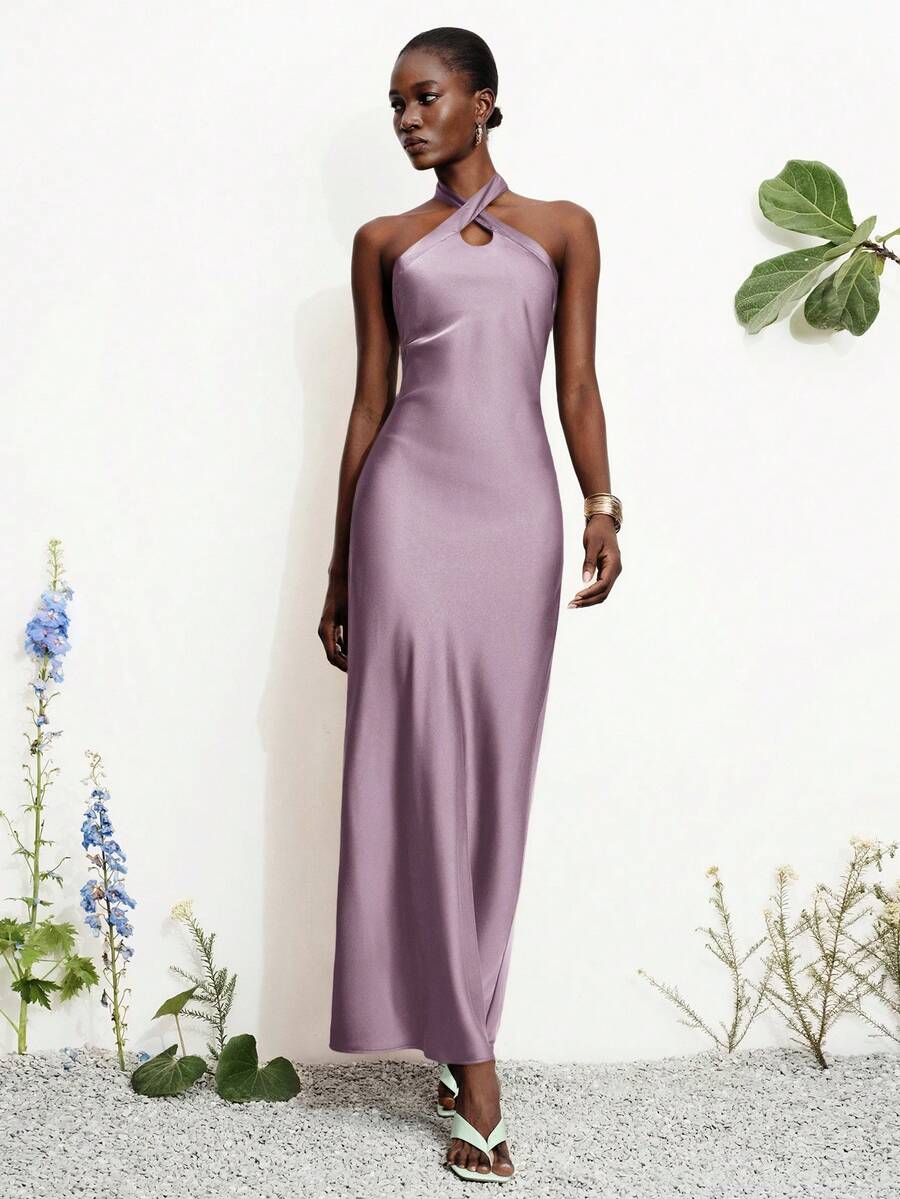 Women's black satin halter neck bodycon midi dress featuring a sleeveless backless design with front slit hem and wrap details.
