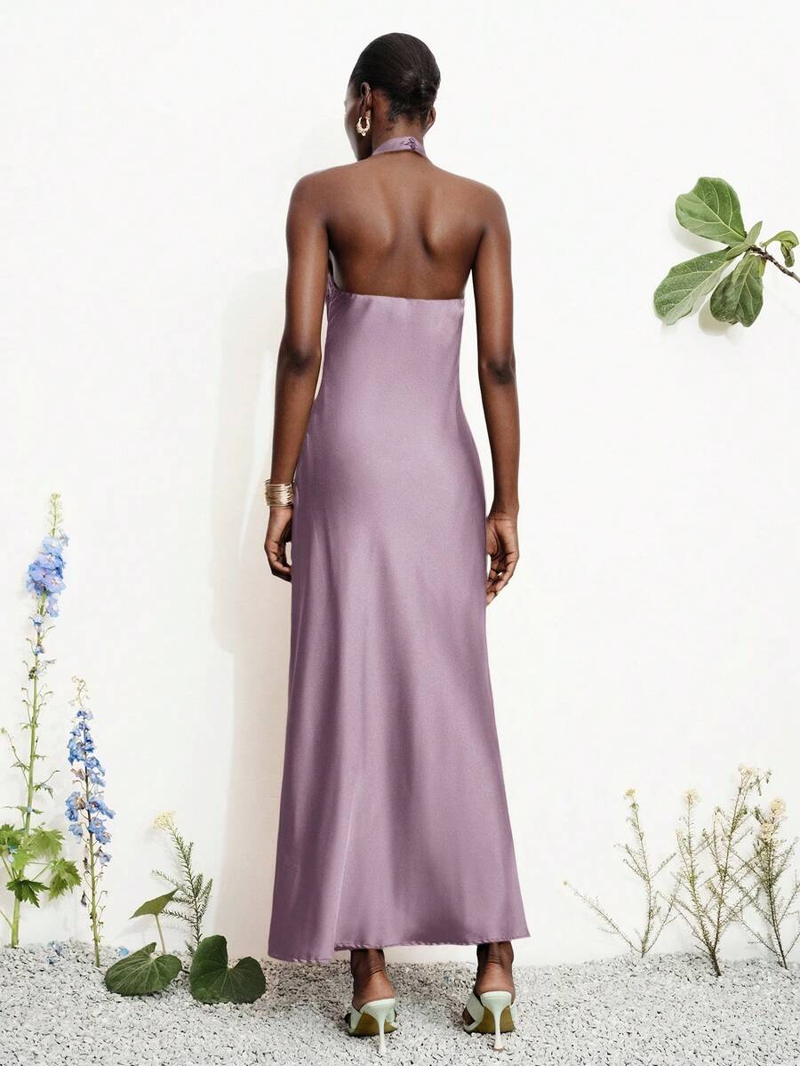 Women's black satin halter neck bodycon midi dress featuring a sleeveless backless design with front slit hem and wrap details.