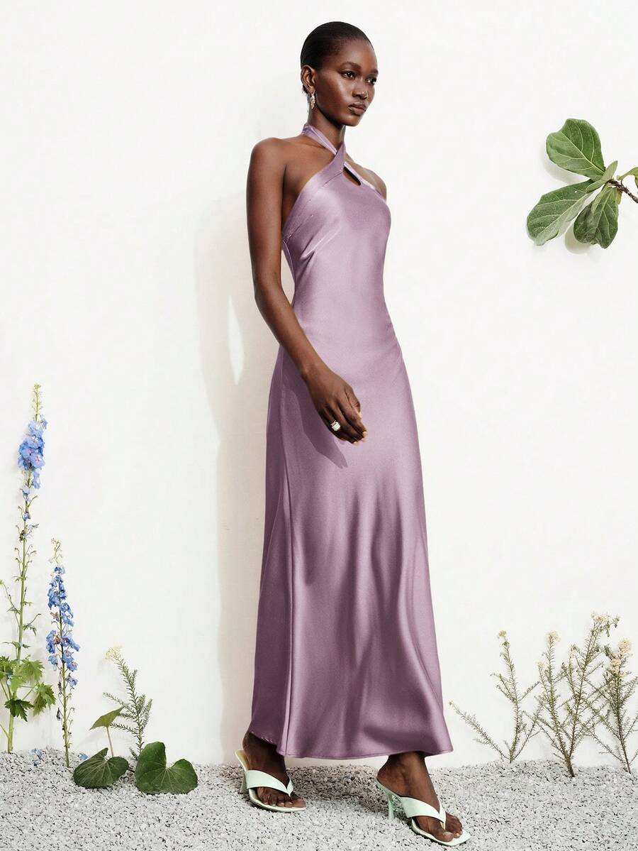 Women's black satin halter neck bodycon midi dress featuring a sleeveless backless design with front slit hem and wrap details.