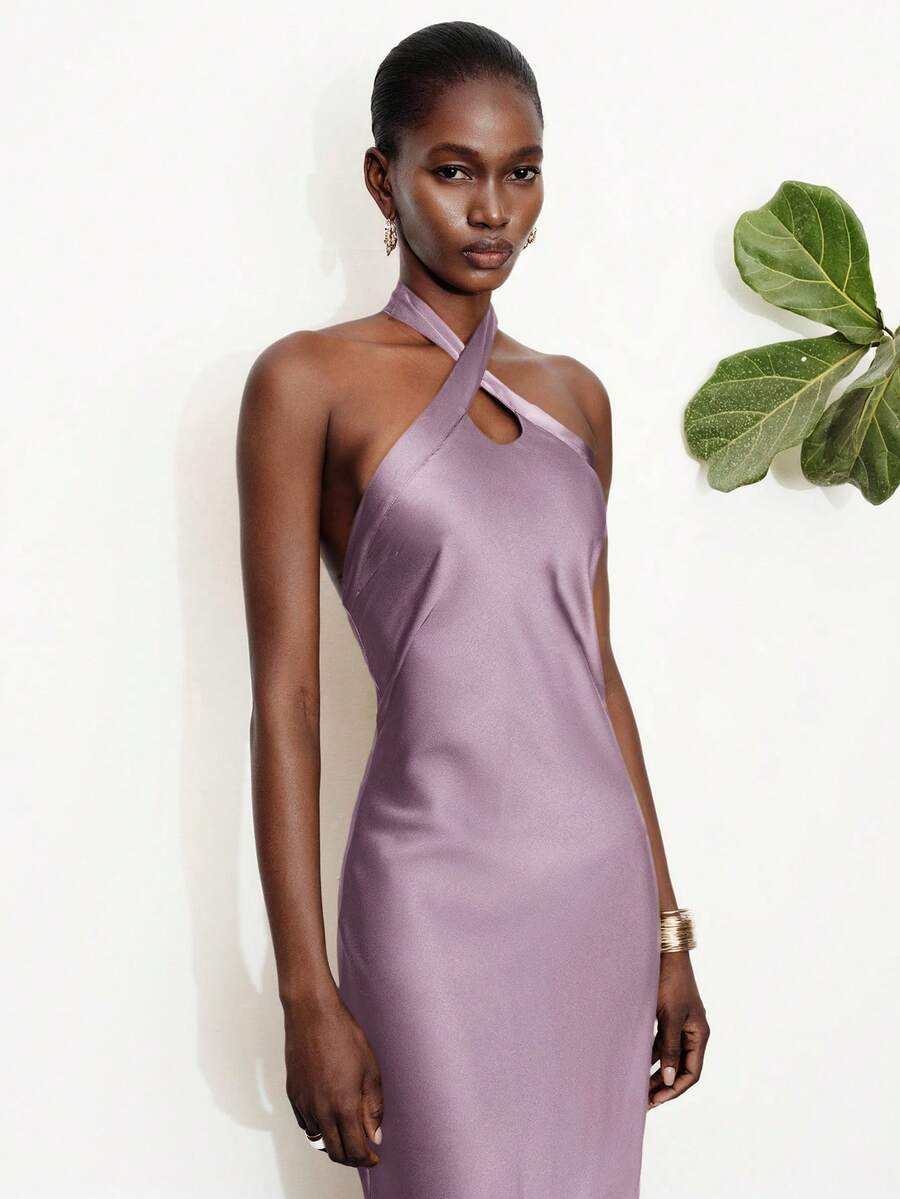 Women's black satin halter neck bodycon midi dress featuring a sleeveless backless design with front slit hem and wrap details.