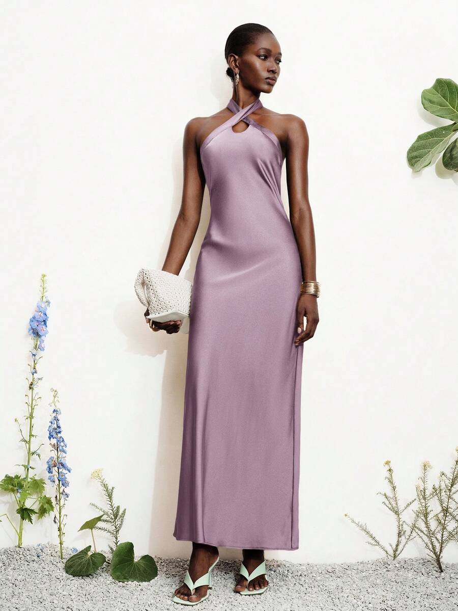 Women's black satin halter neck bodycon midi dress featuring a sleeveless backless design with front slit hem and wrap details.