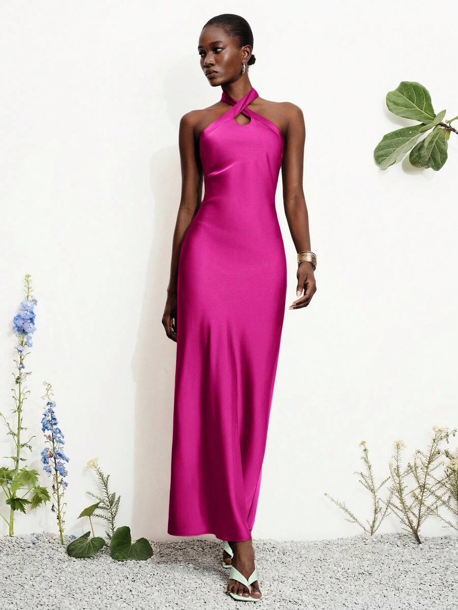 Women's black satin halter neck bodycon midi dress featuring a sleeveless backless design with front slit hem and wrap details.