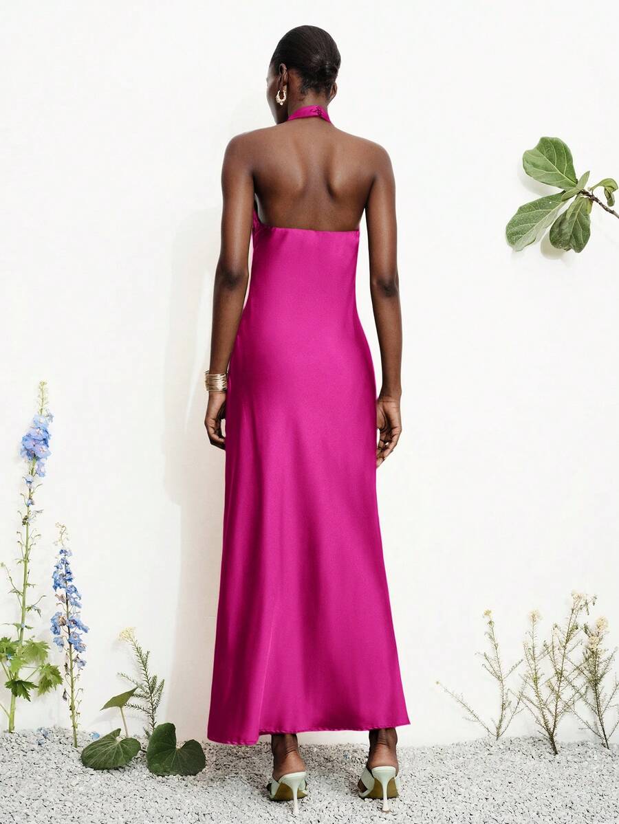 Women's black satin halter neck bodycon midi dress featuring a sleeveless backless design with front slit hem and wrap details.