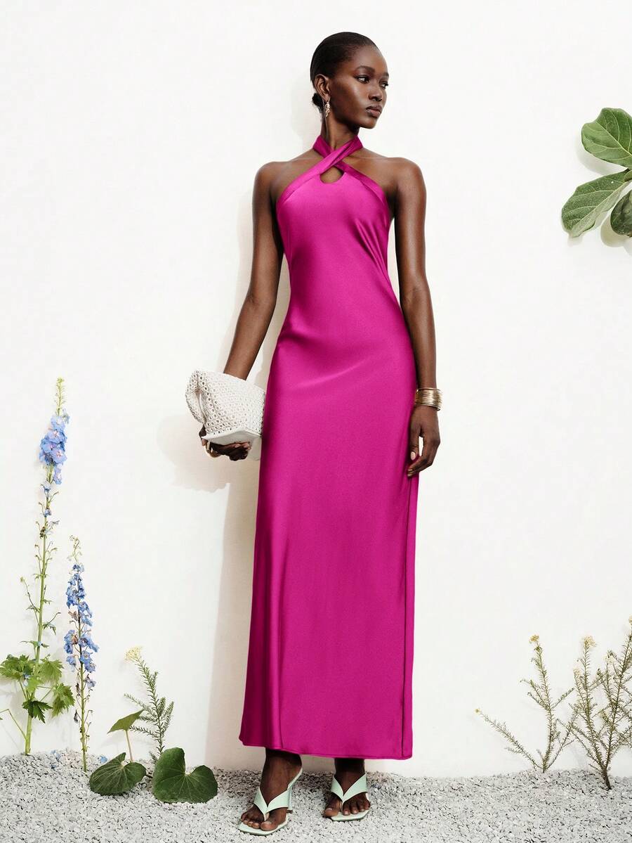 Women's black satin halter neck bodycon midi dress featuring a sleeveless backless design with front slit hem and wrap details.