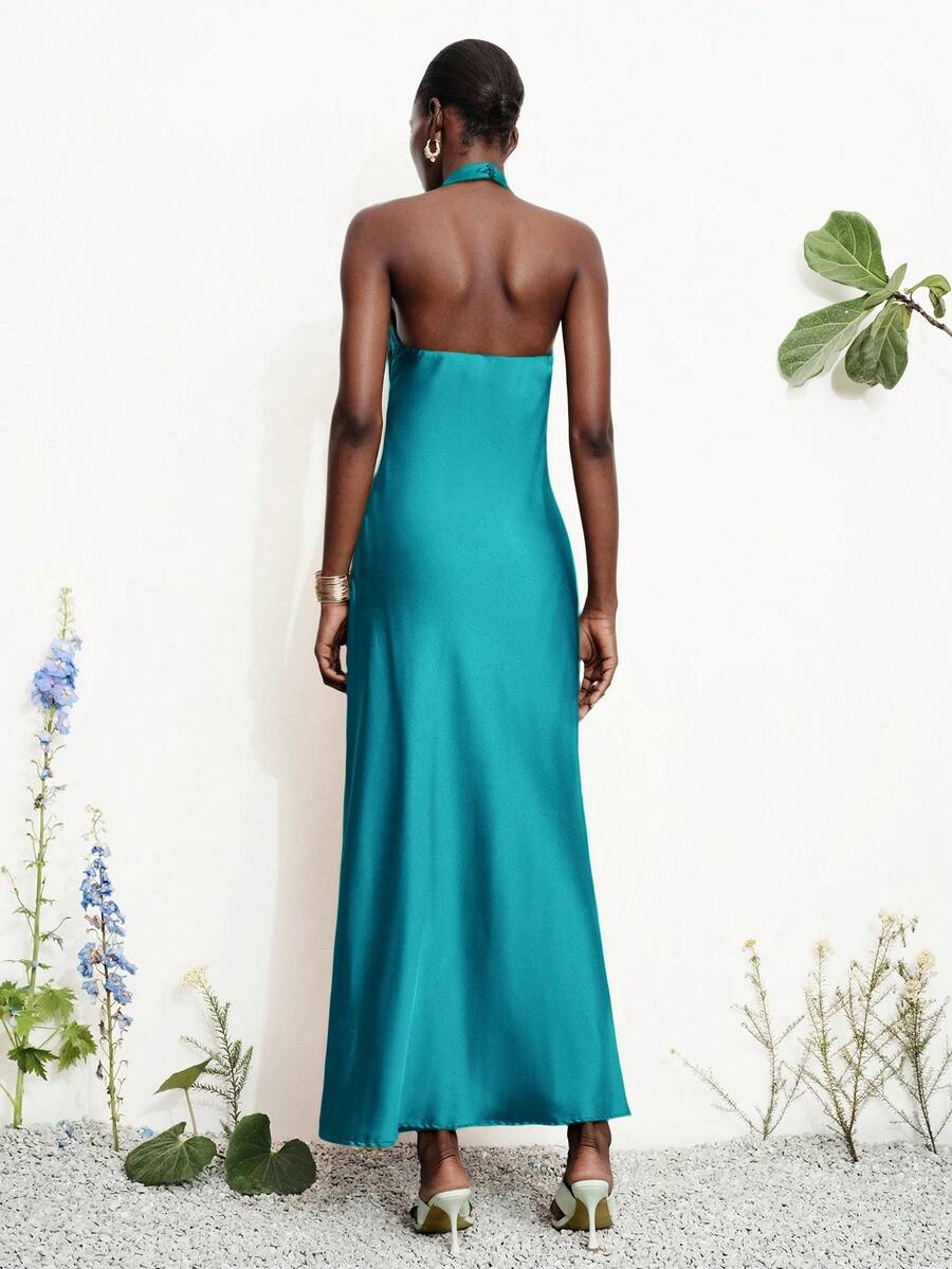 Women's black satin halter neck bodycon midi dress featuring a sleeveless backless design with front slit hem and wrap details.