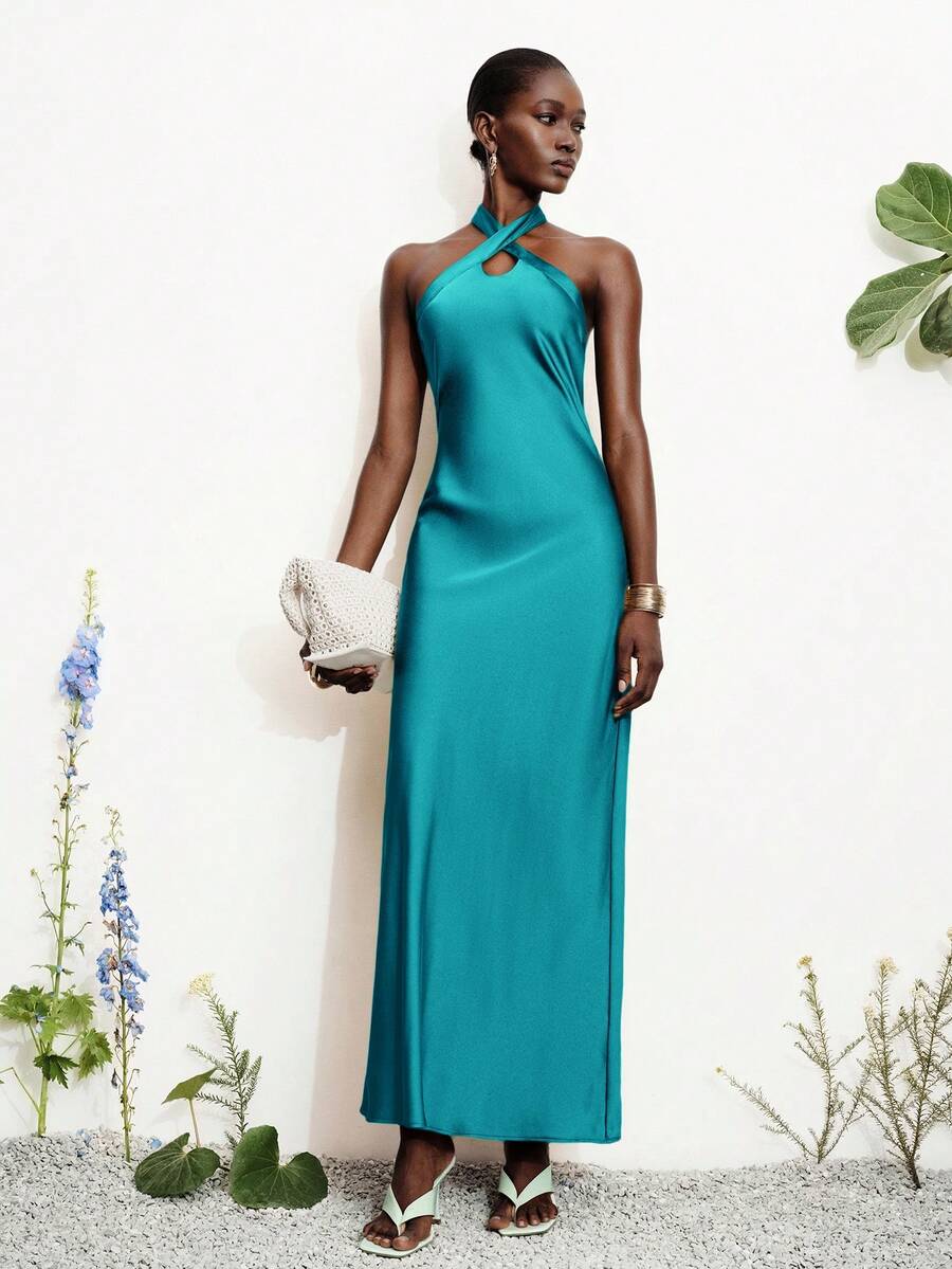 Women's black satin halter neck bodycon midi dress featuring a sleeveless backless design with front slit hem and wrap details.