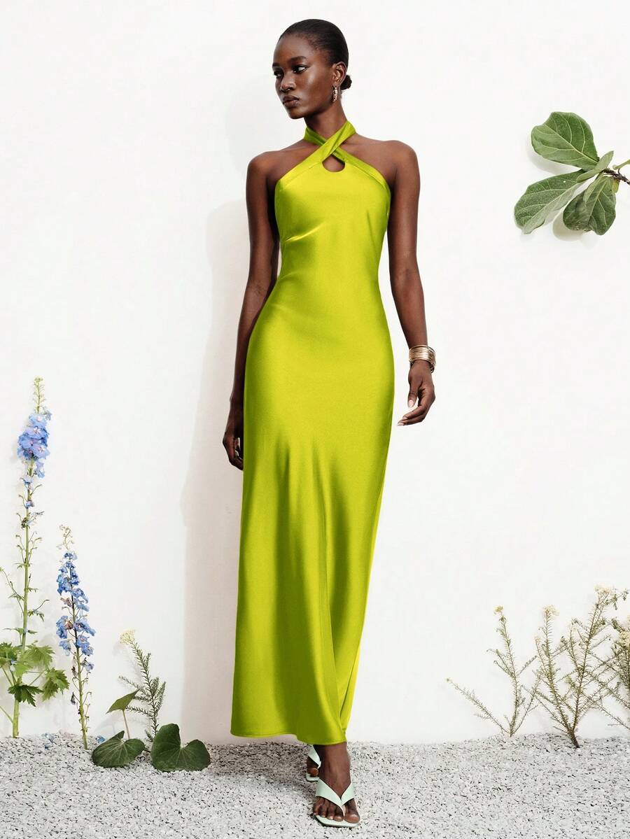 Women's black satin halter neck bodycon midi dress featuring a sleeveless backless design with front slit hem and wrap details.