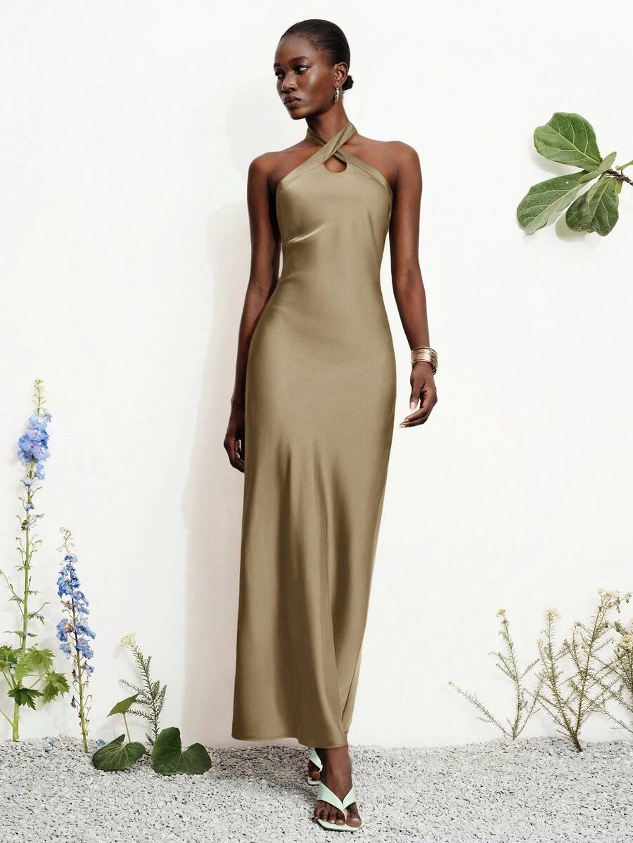 Women's black satin halter neck bodycon midi dress featuring a sleeveless backless design with front slit hem and wrap details.