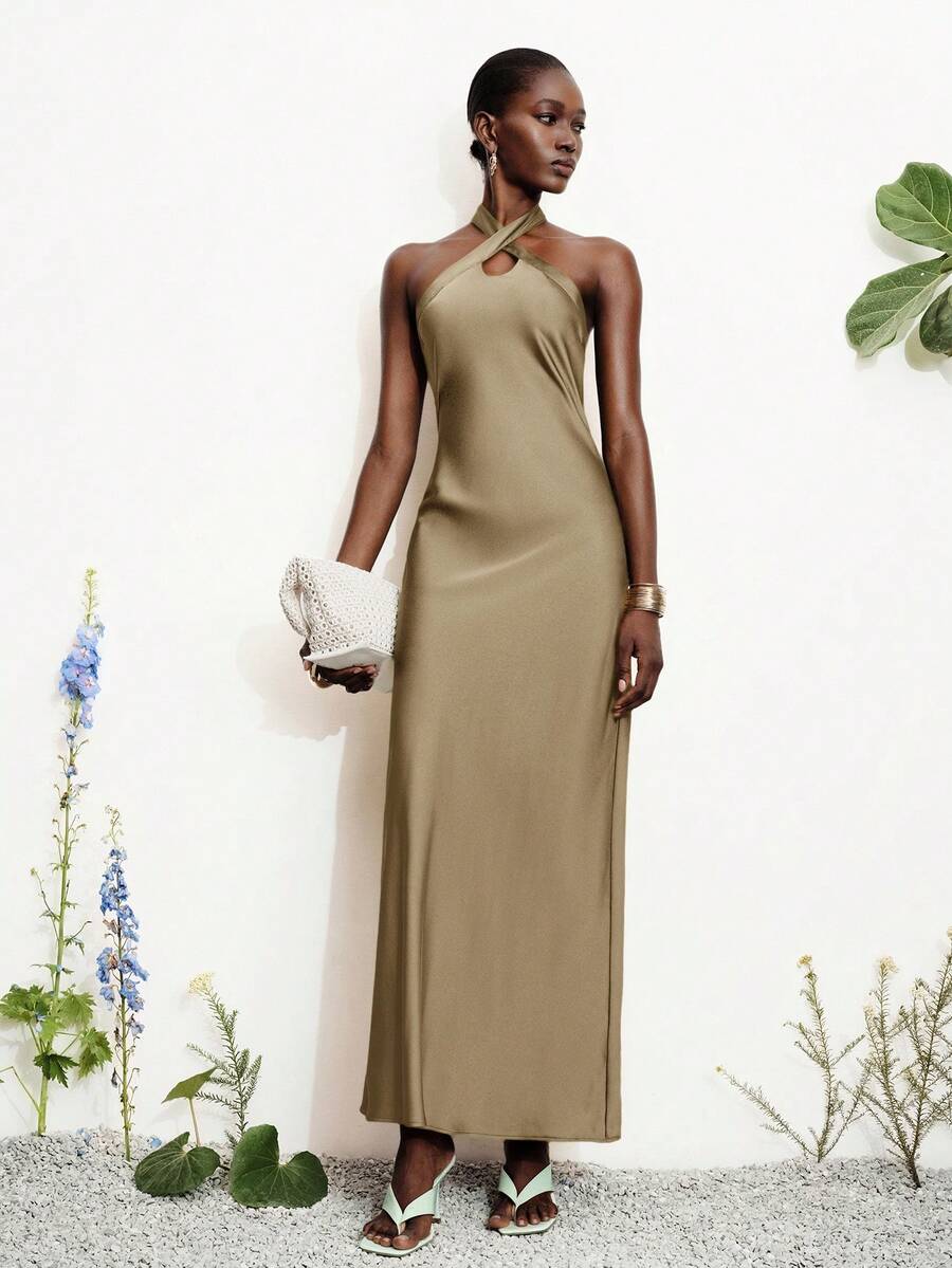 Women's black satin halter neck bodycon midi dress featuring a sleeveless backless design with front slit hem and wrap details.