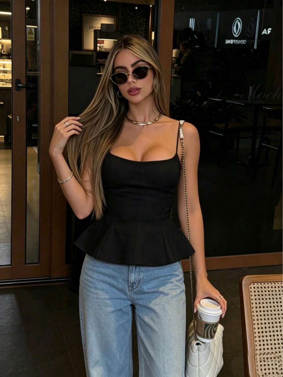 A sleeveless cropped camisole top featuring thin spaghetti straps, a slim fit bodice, and a subtle flared hemline.