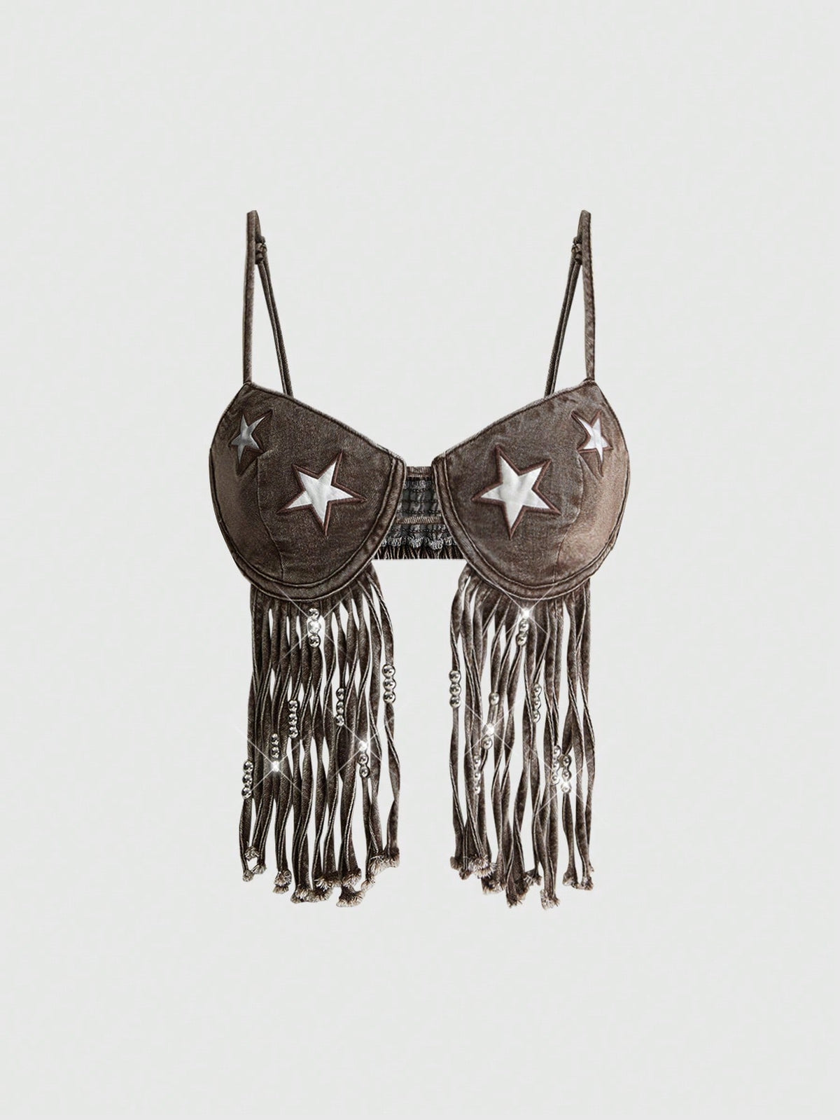 Blue denim camisole top for women featuring star patch detailing, fringe tassel asymmetrical hem, and spaghetti straps.