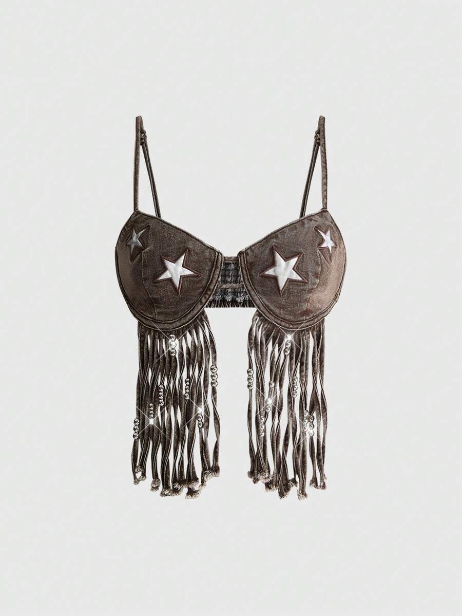 Blue denim camisole top for women featuring star patch detailing, fringe tassel asymmetrical hem, and spaghetti straps.