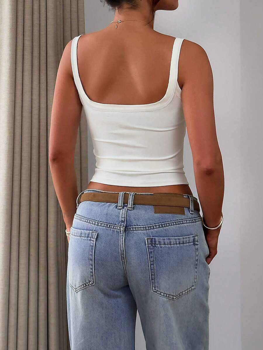 A slim fit women's crop cami tank top with spaghetti straps and a solid color design, made from comfortable stretch knitted fabric.
