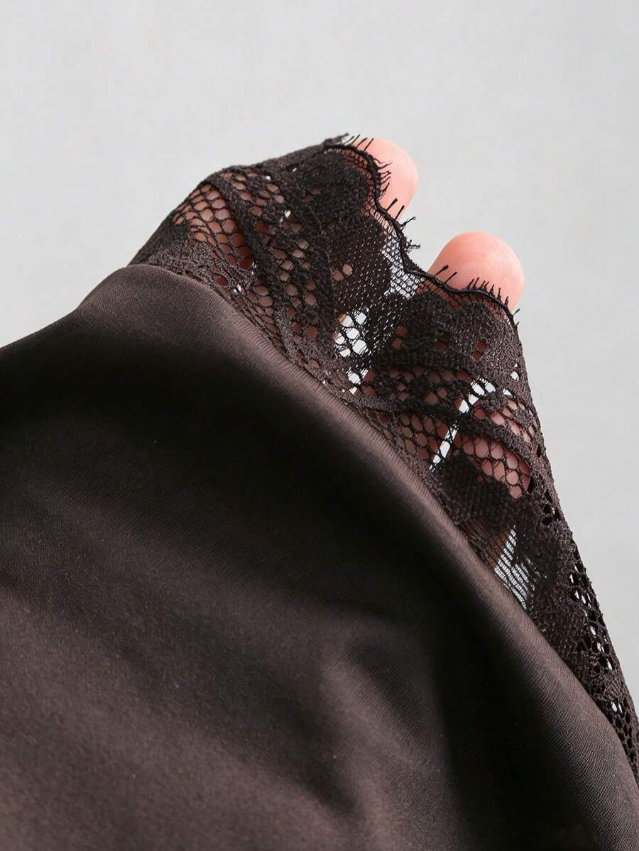 Women's black strapless lace patchwork bodycon mini dress featuring a slim fit design and an asymmetrical hem.