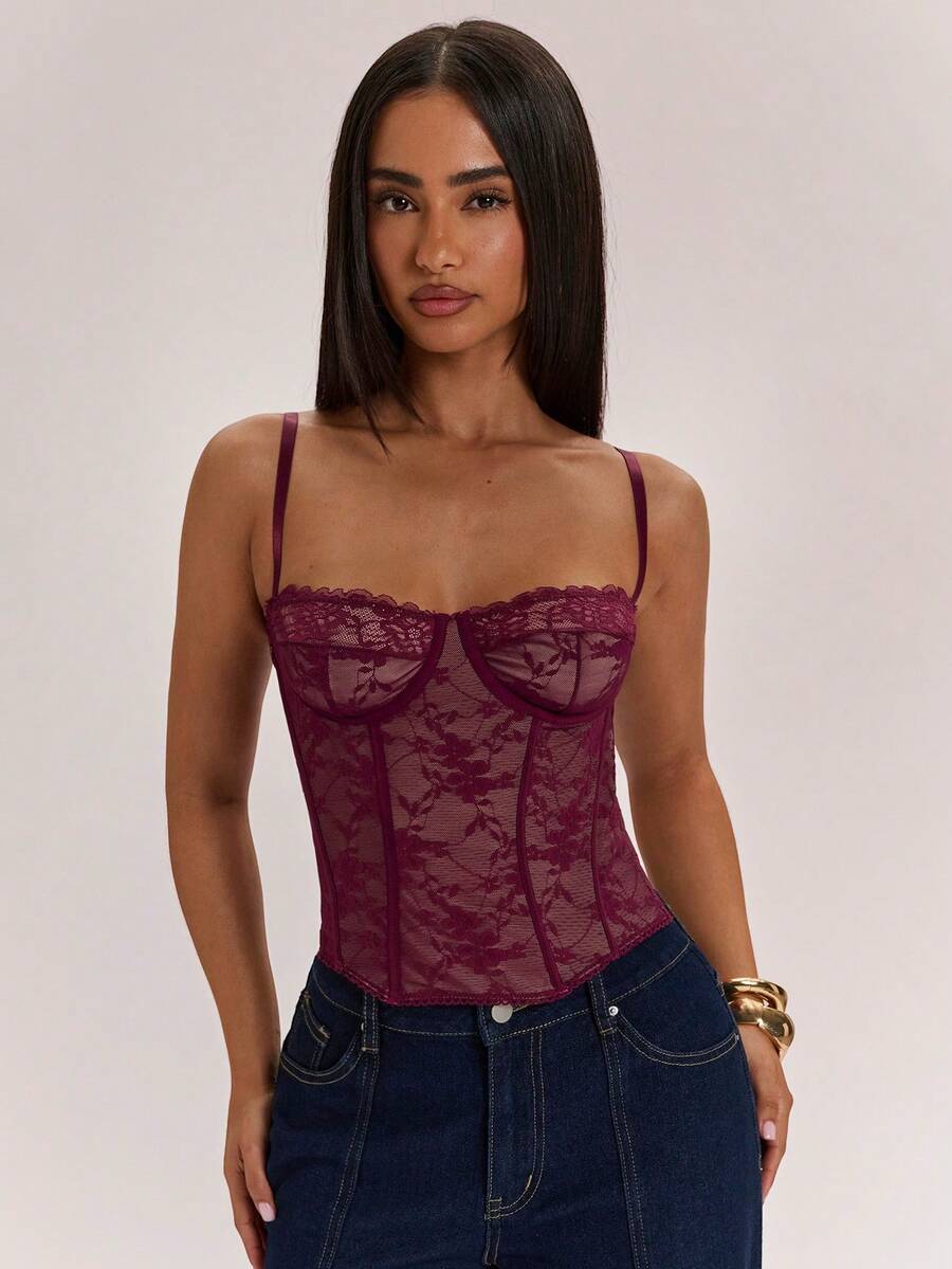 Black women’s lace cami top with spaghetti straps, contrast lace details, and an asymmetrical hem, styled as a slim-fit lined casual top.
