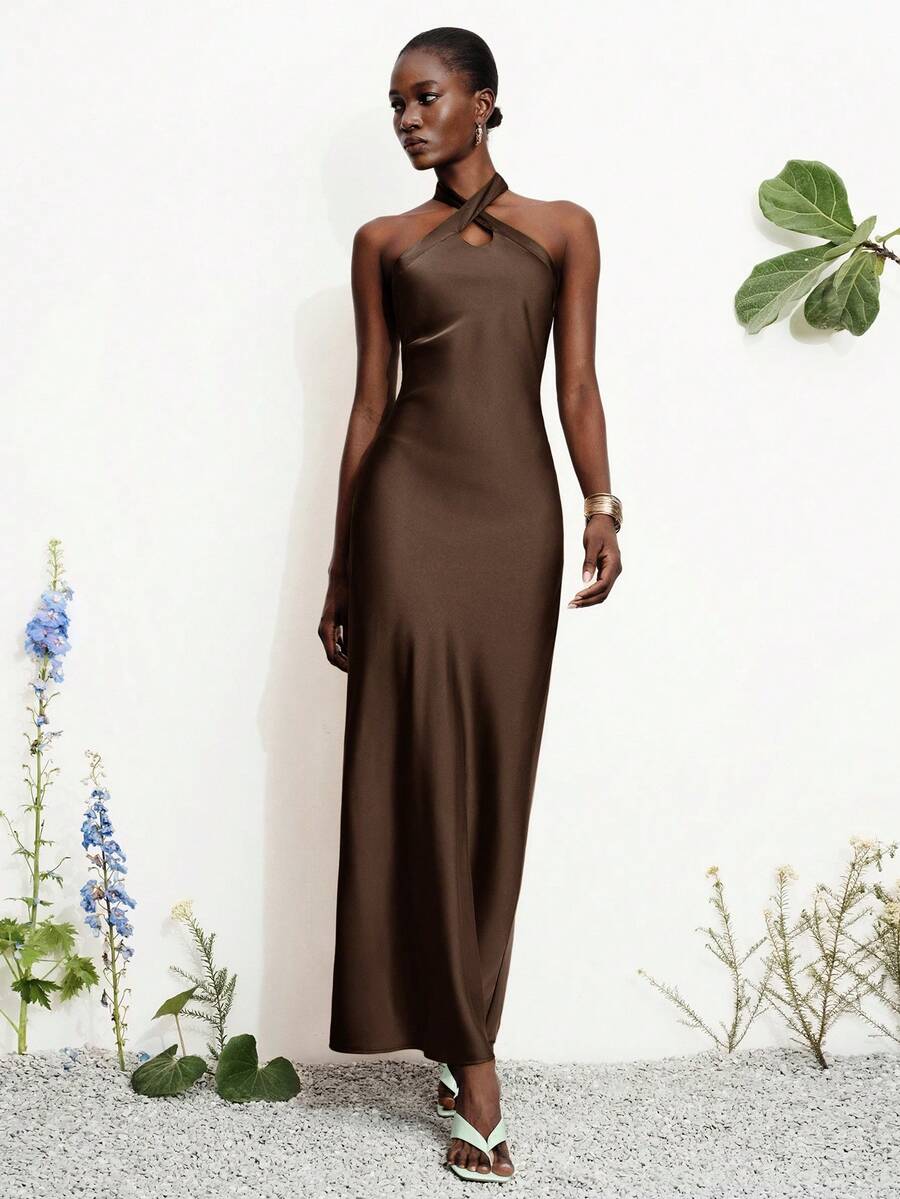 Women's black satin halter neck bodycon midi dress featuring a sleeveless backless design with front slit hem and wrap details.