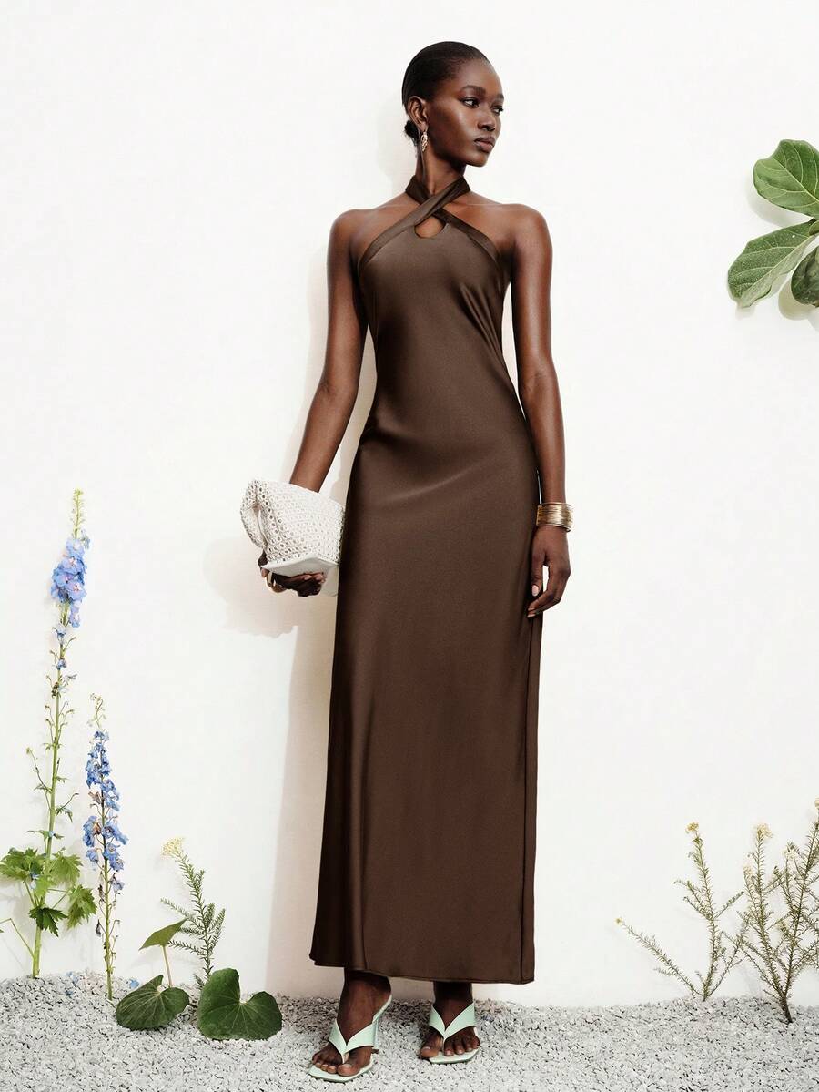 Women's black satin halter neck bodycon midi dress featuring a sleeveless backless design with front slit hem and wrap details.