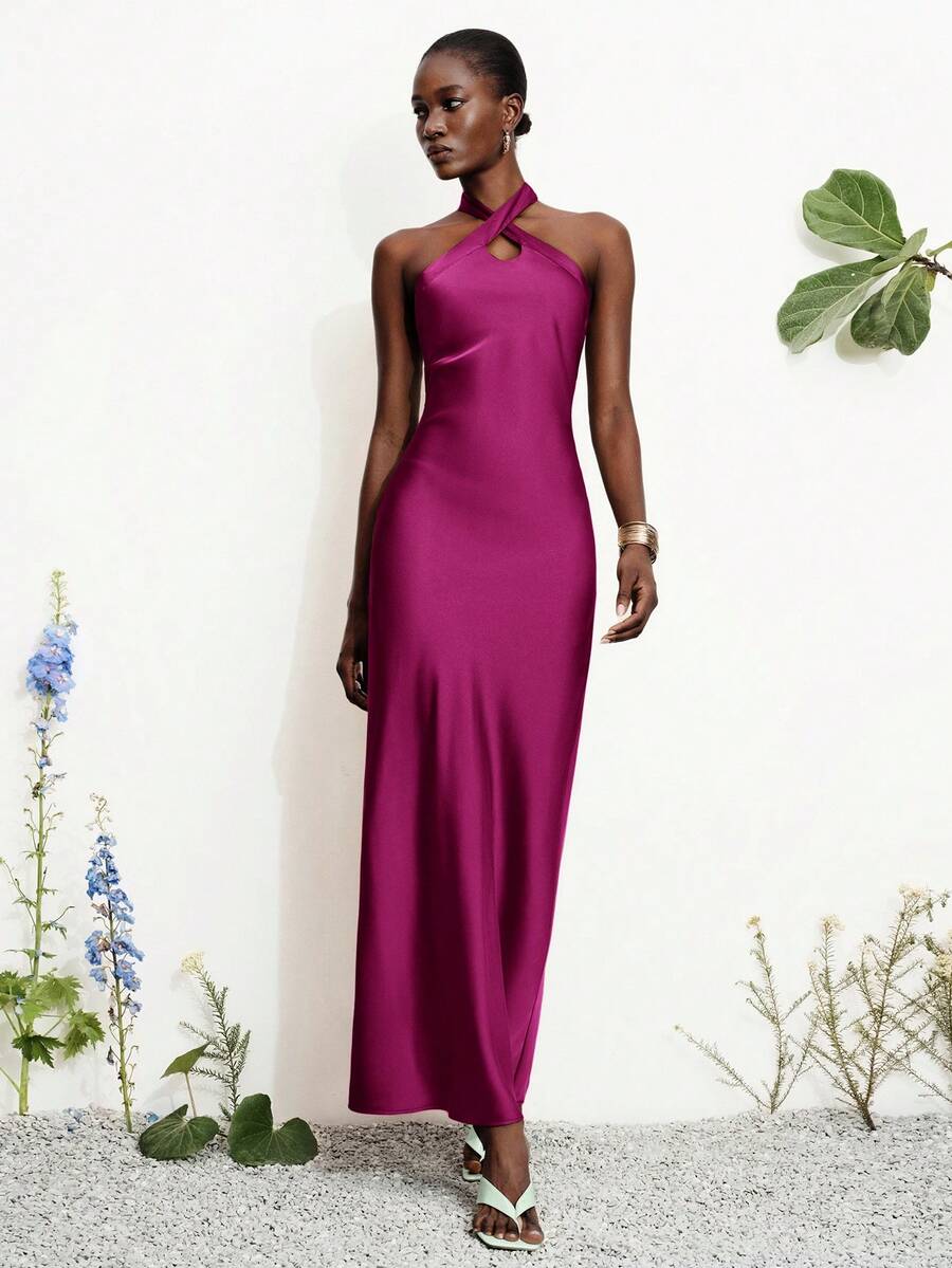 Women's black satin halter neck bodycon midi dress featuring a sleeveless backless design with front slit hem and wrap details.