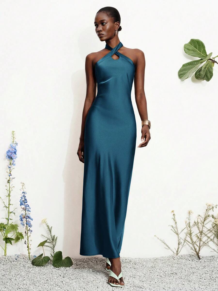 Women's black satin halter neck bodycon midi dress featuring a sleeveless backless design with front slit hem and wrap details.