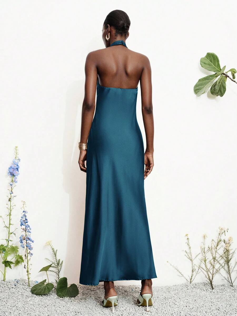 Women's black satin halter neck bodycon midi dress featuring a sleeveless backless design with front slit hem and wrap details.