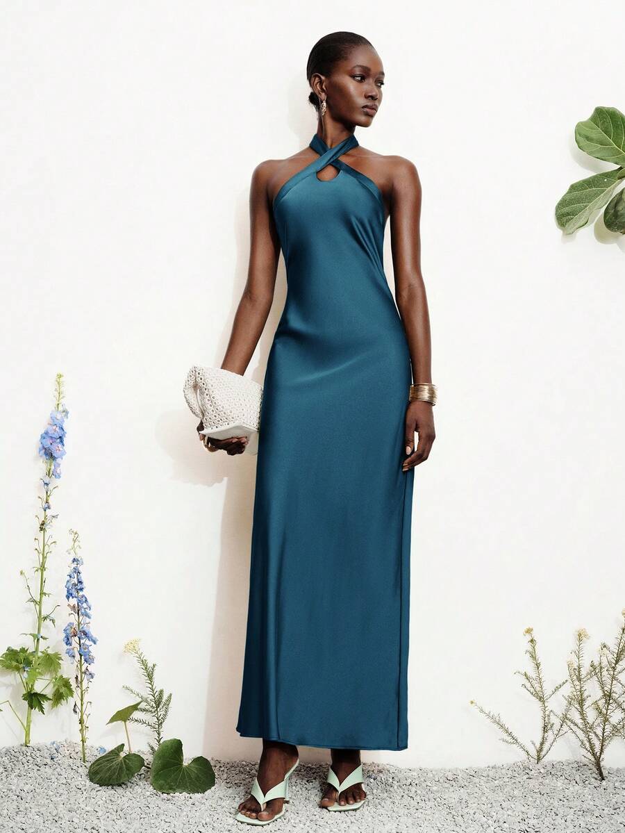 Women's black satin halter neck bodycon midi dress featuring a sleeveless backless design with front slit hem and wrap details.